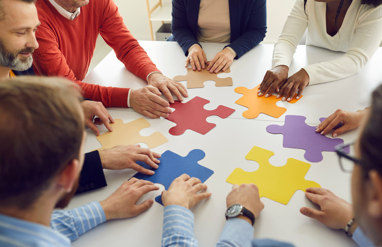 Diverse Multiethnic People Group Collaborating Assembling Puzzle Pieces Together